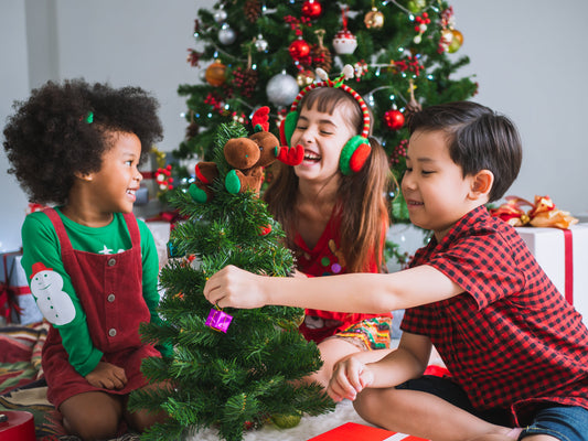 Kids decorating miniature pine tree as a fun Christmas party game