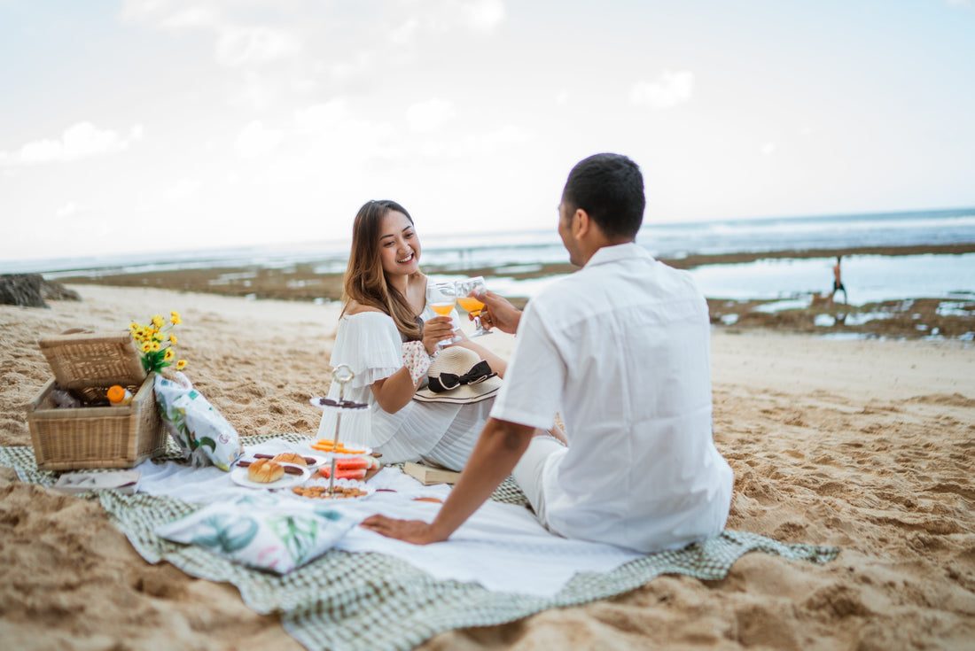 Young Asian couple enjoying a beach picnic