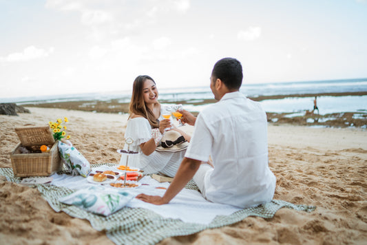 Young Asian couple enjoying a beach picnic